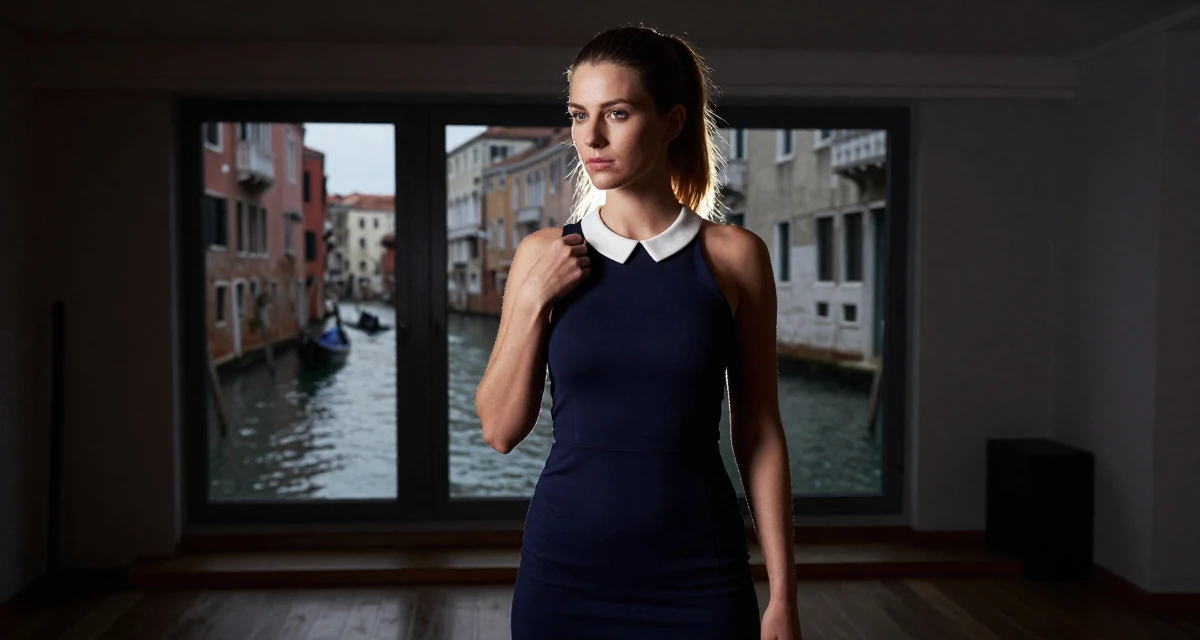 A coy Female From Hamburg Germany, majored in sociology in their 24, balancing sensuality with authenticity, wearing a navy blue dress with white collar and cuffs, adjusting a shoulder strap in a yoga studio.