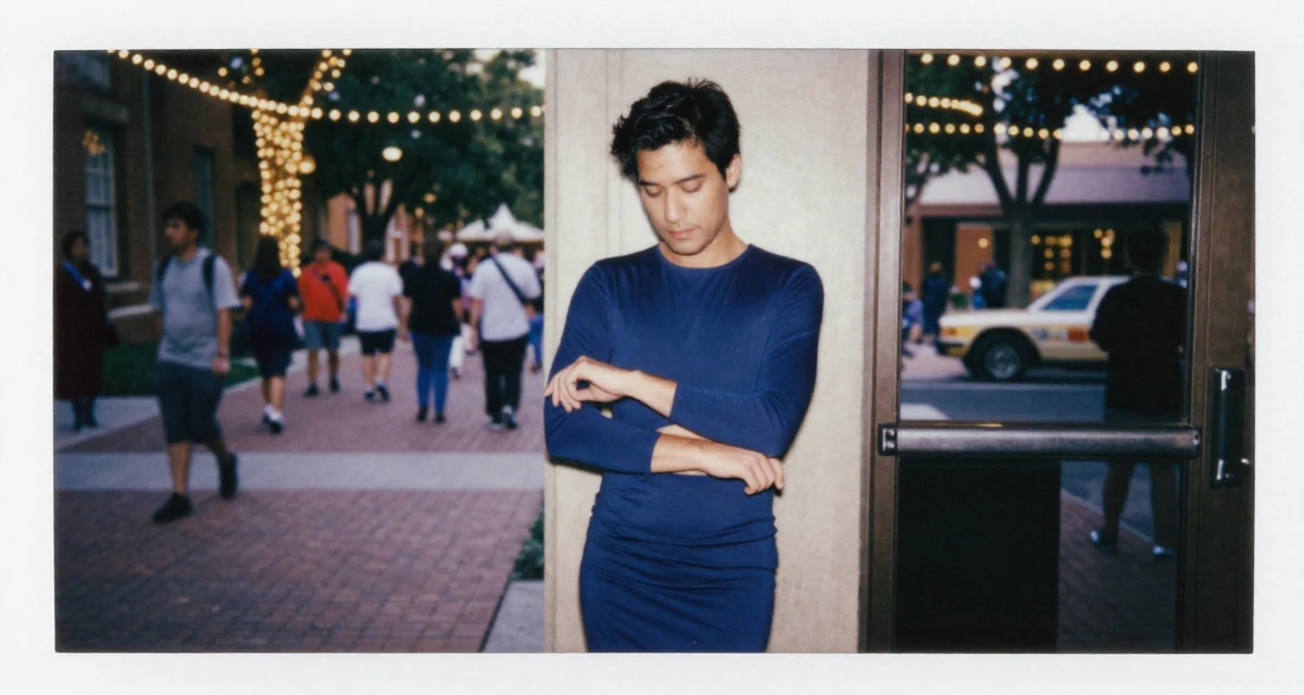 A tranquil male From Las Vegas USA, learned burlesque performance and crowd engagement in their 38, handling long working hours, wearing a fitted midi dress with a cutout at the waist, adjusting sleeves in a university campus.