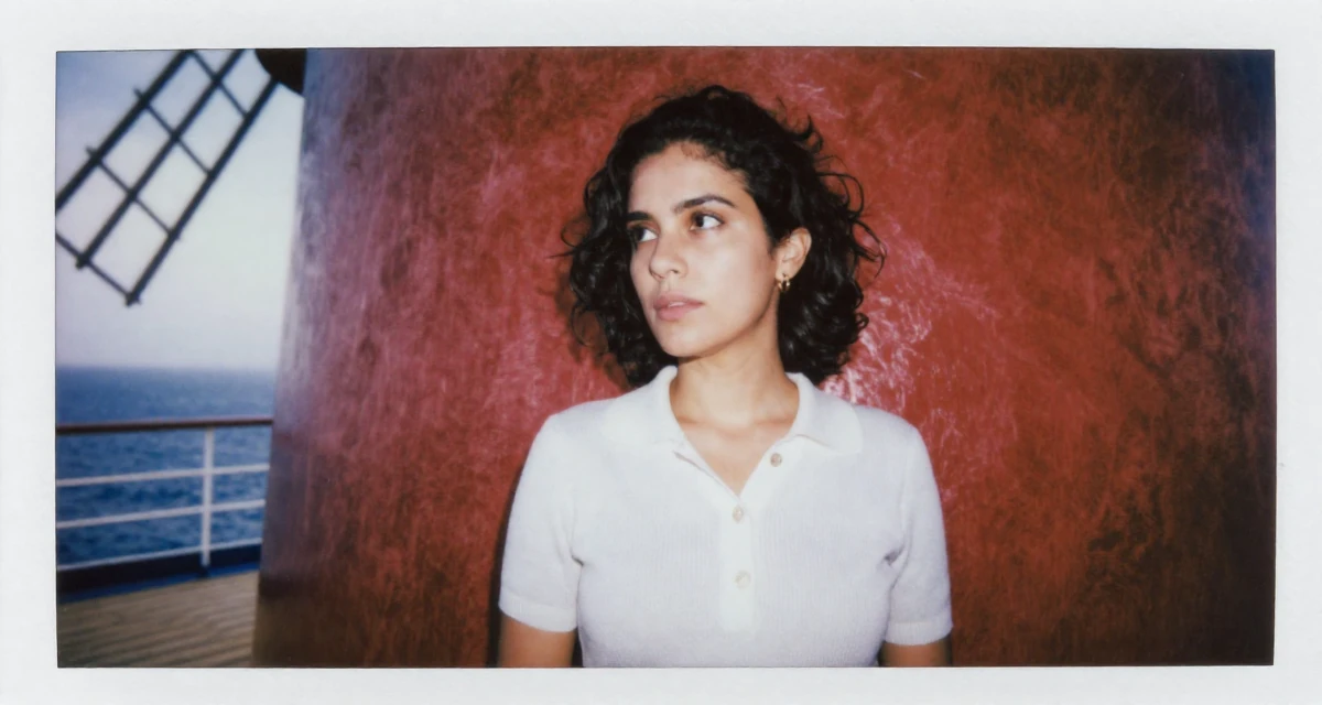 A fascinated Female From Brazil, studied fashion merchandising in their 34, redefining what success means personally, wearing a smart knit polo, glancing over the shoulder in a cruise ship deck.