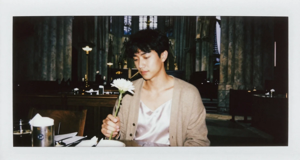 A quiet male From United States, majored in hospitality operations in their 34, managing mortgage payments, wearing a white silk camisole and a beige cardigan, holding a single flower in a gothic cathedral interior.