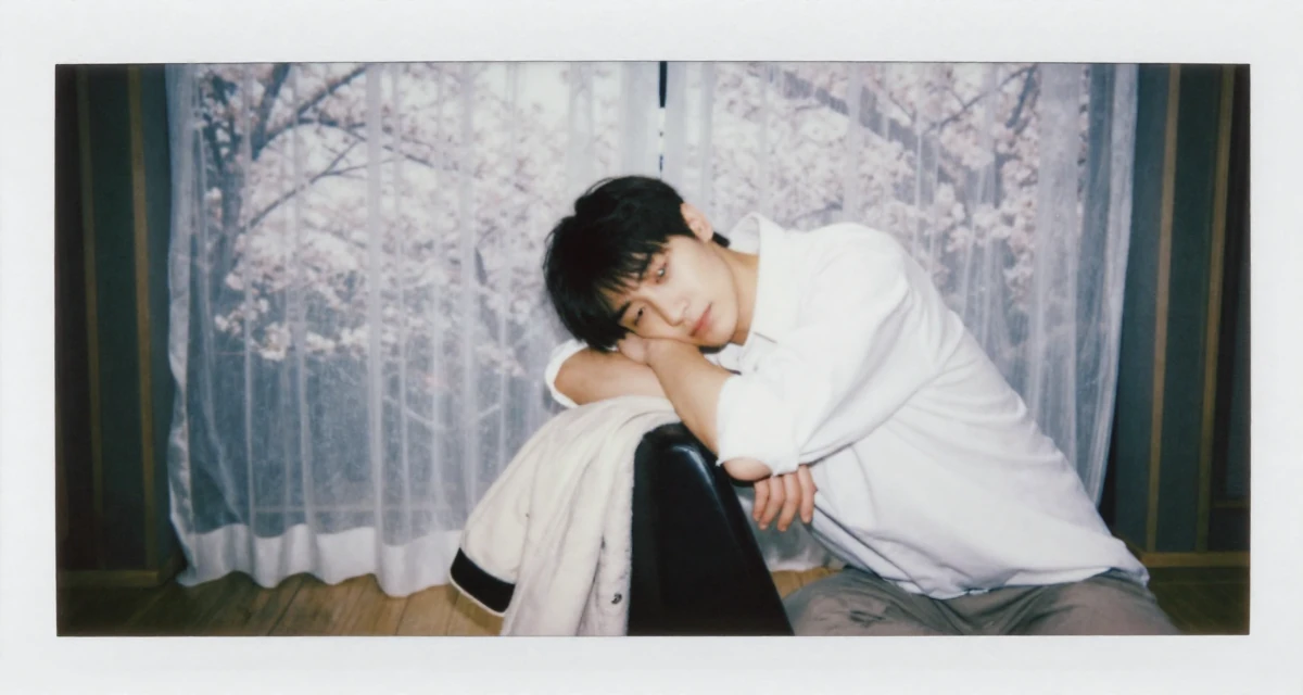 A serene and peaceful male From Chongqing China, trained in yoga and body-movement expression in their 32, managing long-distance relationship, wearing a oversized white shirt with sleeves rolled up and slim trousers, putting on a jacket in a music studio.