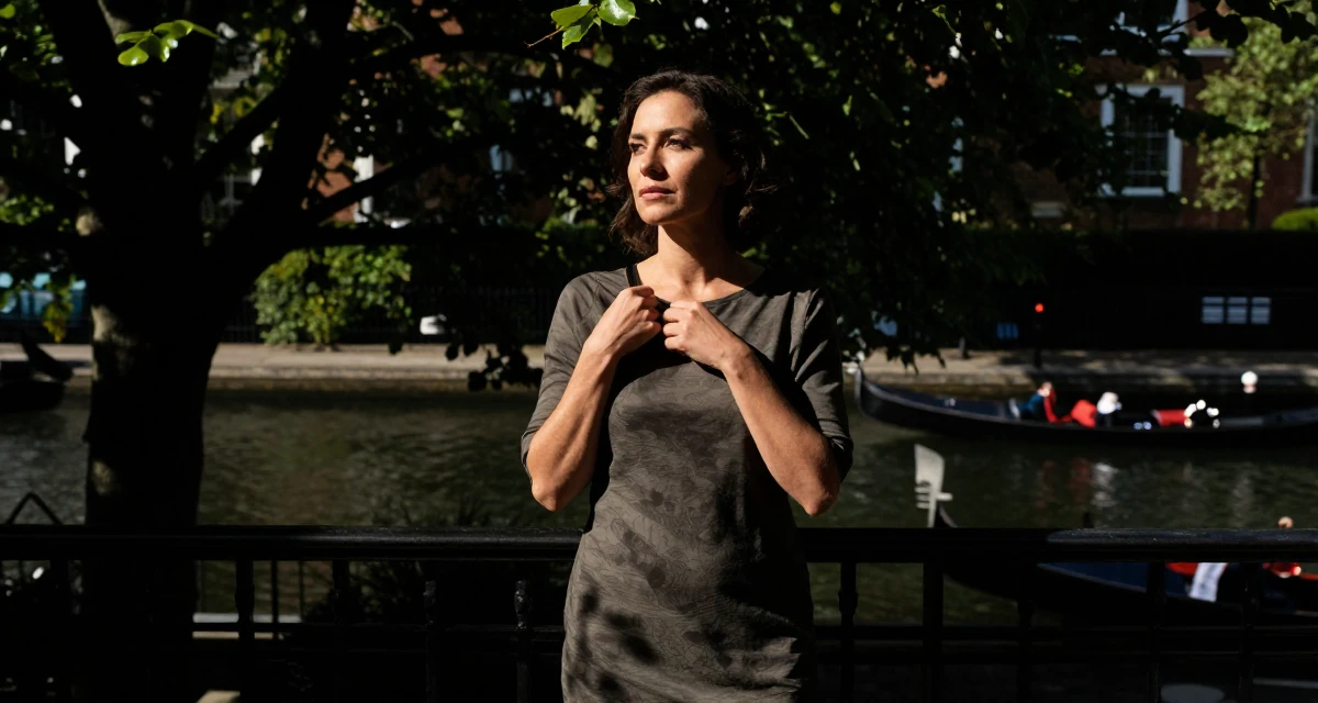 A serene Female From UK, trained in musical theatre in their 30, standing tall with unshakeable dignity, wearing a t-shirt dress with the sleeves rolled up, adjusting a shoulder strap in a luxury penthouse balcony.