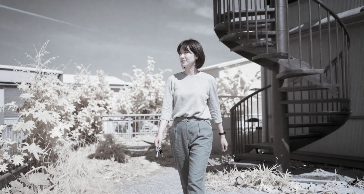 A pleased Female From Japan, studied English literature in their 46, transitioning from employee to founder, wearing a minimalist everyday clothing, holding a set of keys in a music studio.